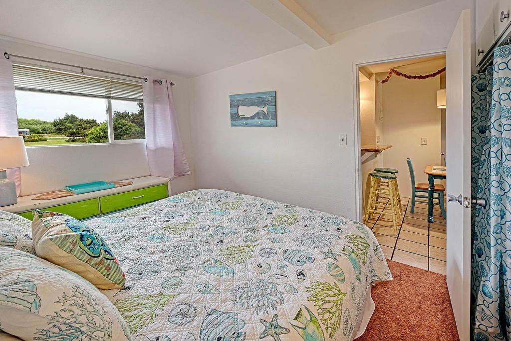 1 dormitorio con cama, ventana y mesa en Shine On Condo, en Ocean Shores