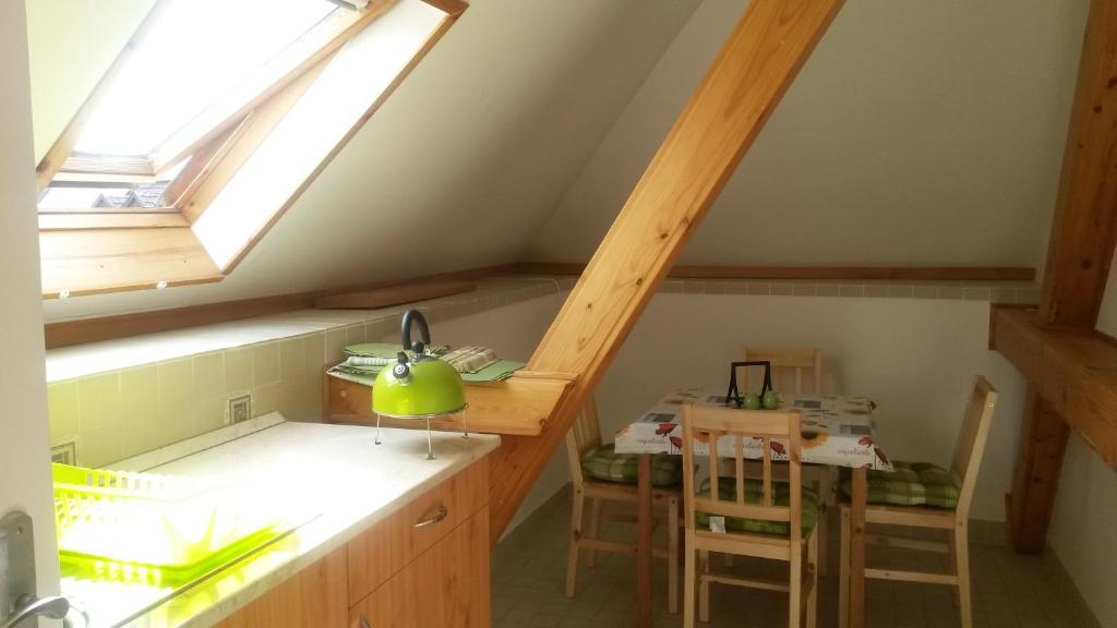 a kitchen with a skylight and a table in a room at Hold-on apartman in Gyula