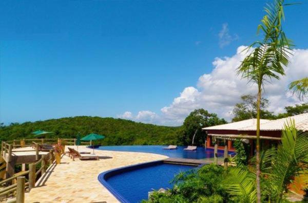 una piscina en un complejo con árboles en el fondo en Villas Pratagy Resort, en Maceió