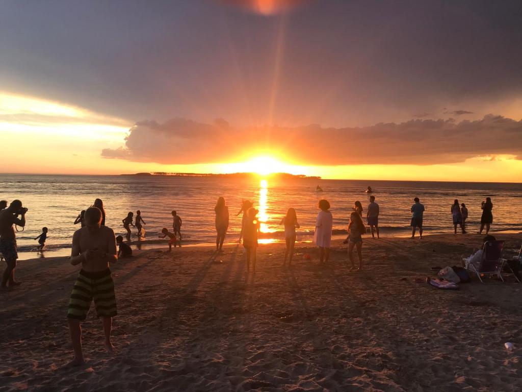 a group of people playing on the beach at sunset at Apart Hotel El Caracol in José Ignacio