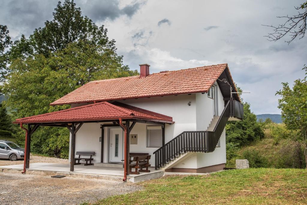 una pequeña casa blanca con techo rojo en Nonči, en Selište Drežničko