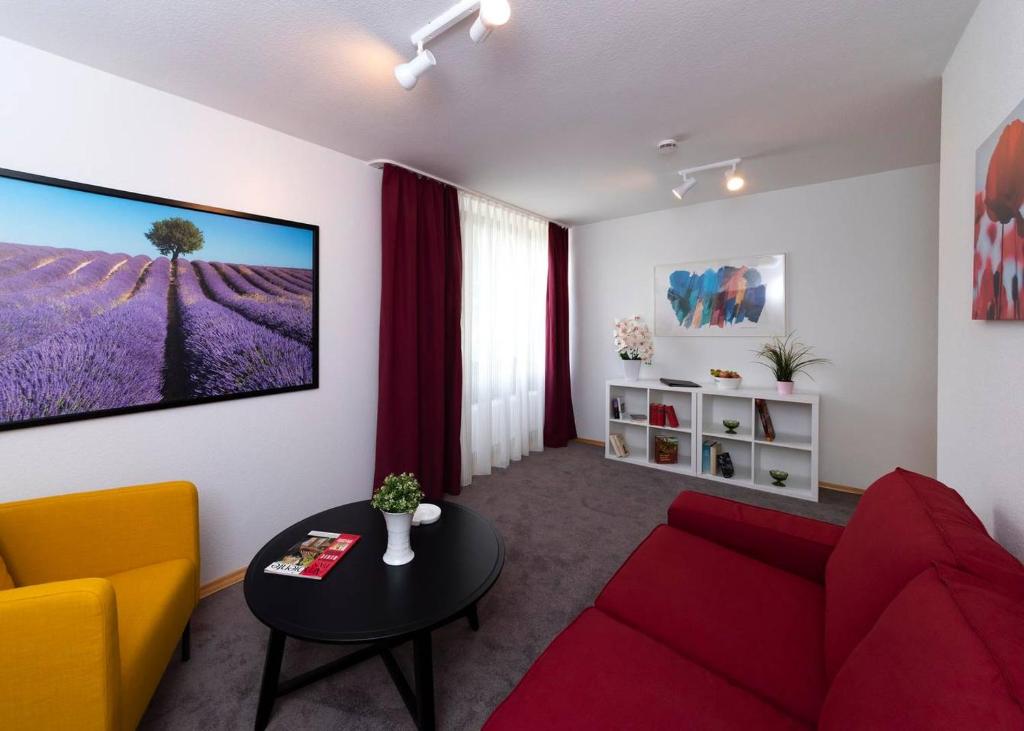 ein Wohnzimmer mit einem roten Sofa und einem Tisch in der Unterkunft Bergblick Appartement in Ober-Hambach