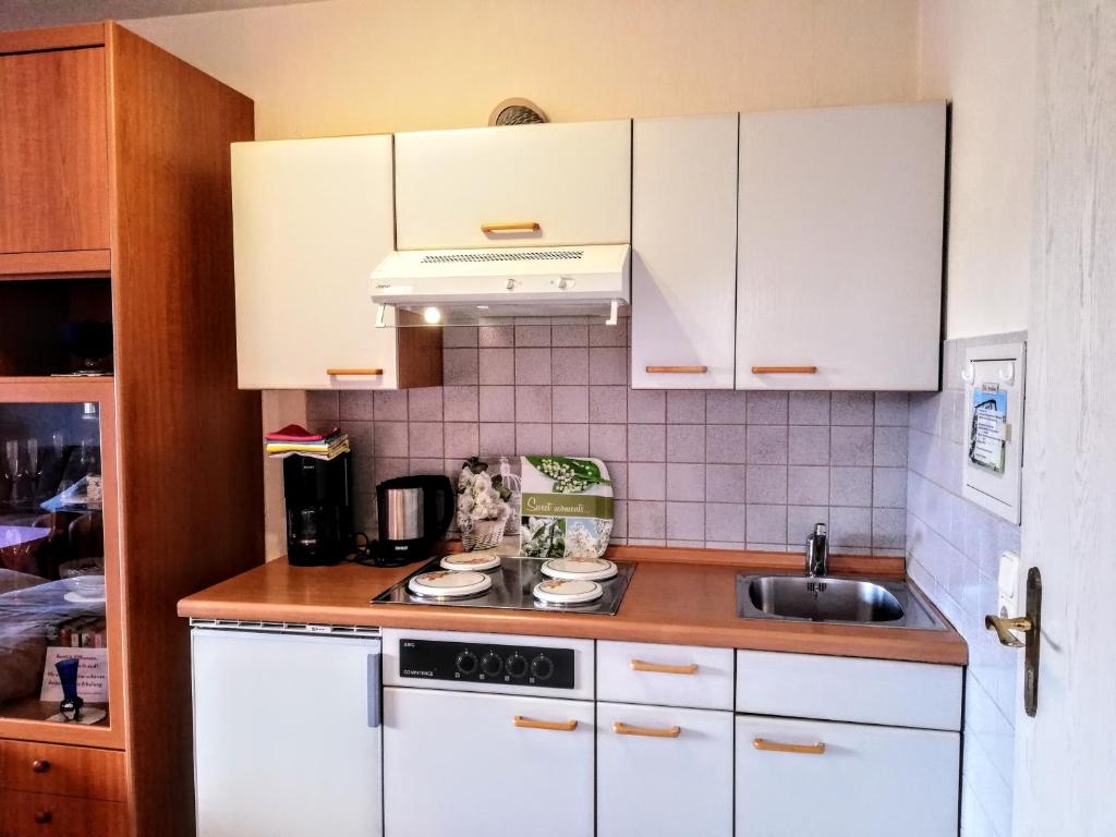 a kitchen with white cabinets and a sink at Haus Royal in Bad Wildungen