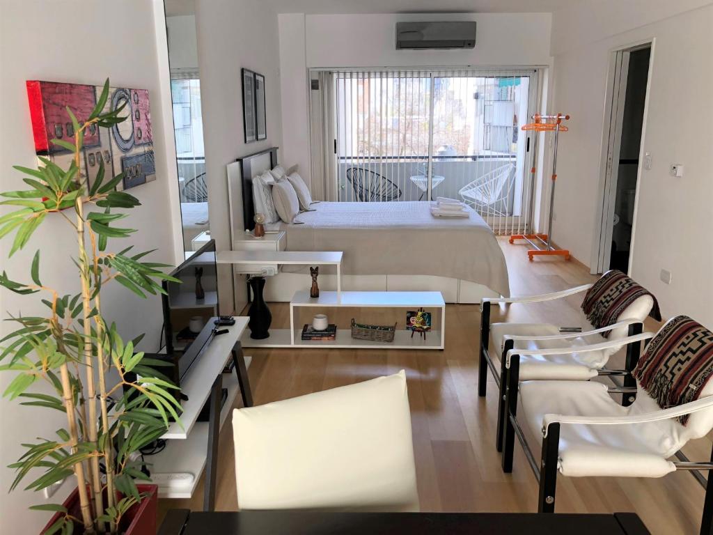 1 dormitorio con 1 cama, mesa y sillas en Petite Maison en Buenos Aires