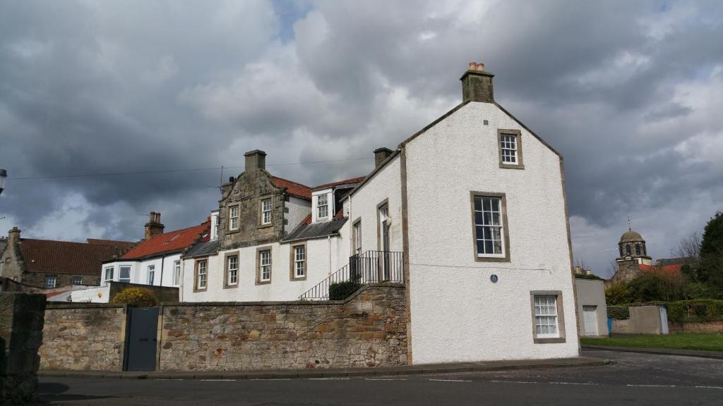 um grande edifício branco com uma parede de tijolos em John McDouall Stuart View em Dysart