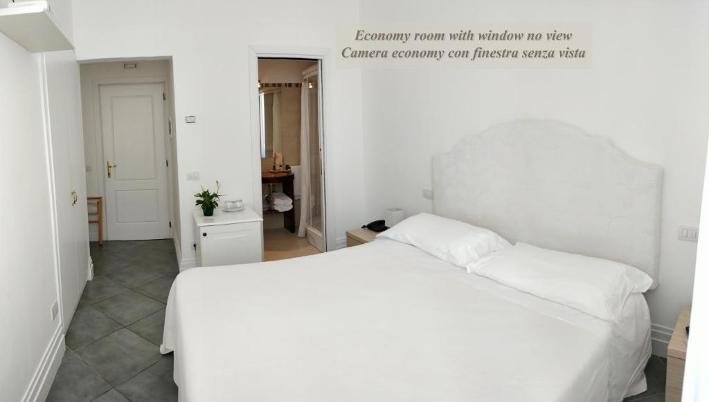 a white bed with two pillows in a bedroom at Hotel Marincanto in Positano