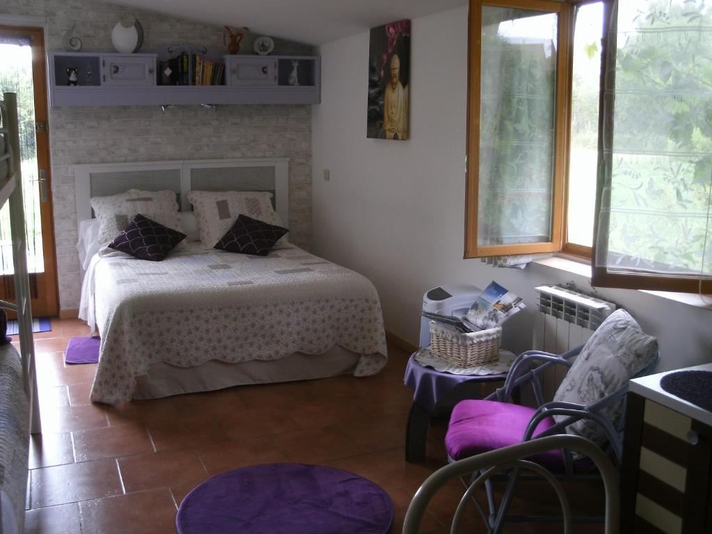 um quarto com uma cama com almofadas roxas em Chambres d'hotes du Moulin em Saint-Julien-sur-Cher