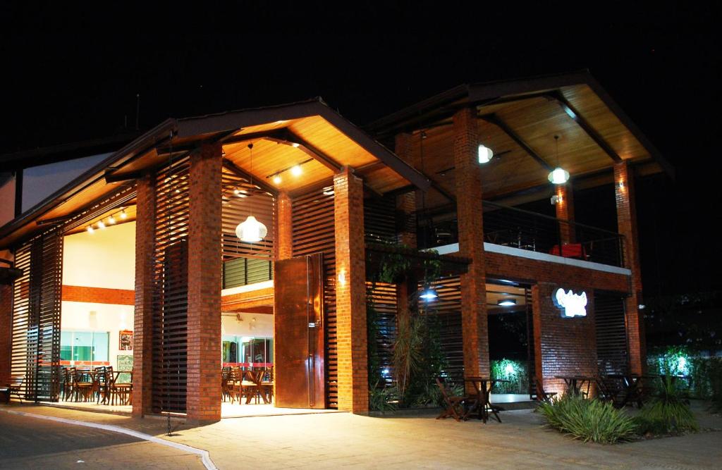 a large brick building with tables and chairs at night at Villa Rio Branco Hotel Concept in Rio Branco
