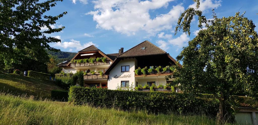 a white house with plants on the side of it at Gasthaus Ratsstüble Garni in Simonswald