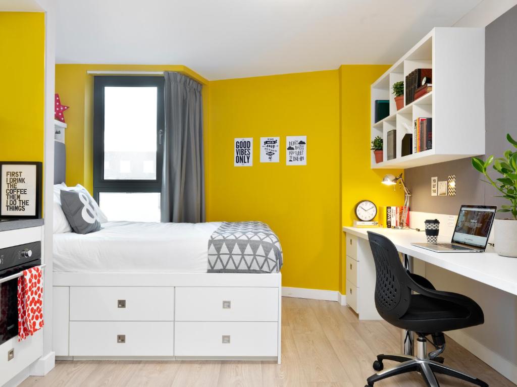 エディンバラにあるStudent Castleの黄色の壁のベッドルーム(ベッド1台、デスク付)