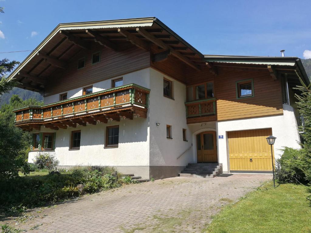 a house with a yellow door and a balcony at Landhaus Breitenberg in Bad Hofgastein