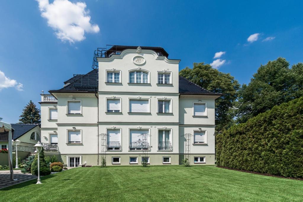 un gran edificio blanco con un reloj en él en Hotel Villa am Waldschlösschen, en Dresden