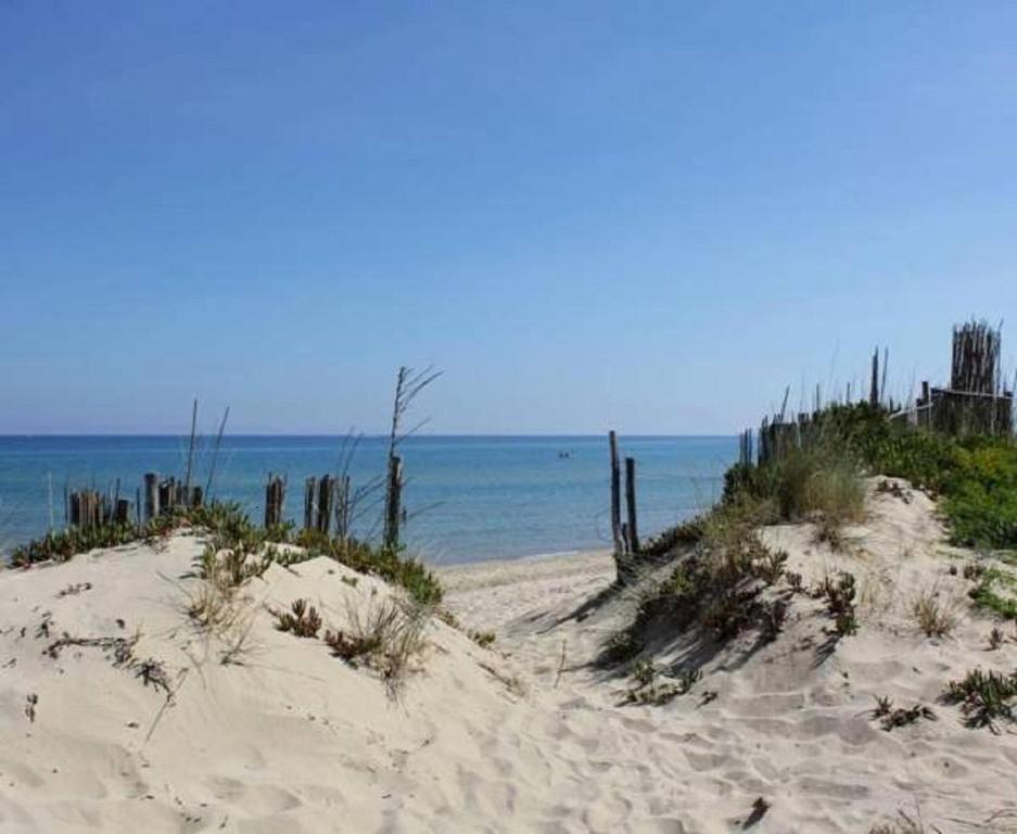 a sandy beach with a fence and the ocean at Casevacanza Soleluna in Alcamo Marina