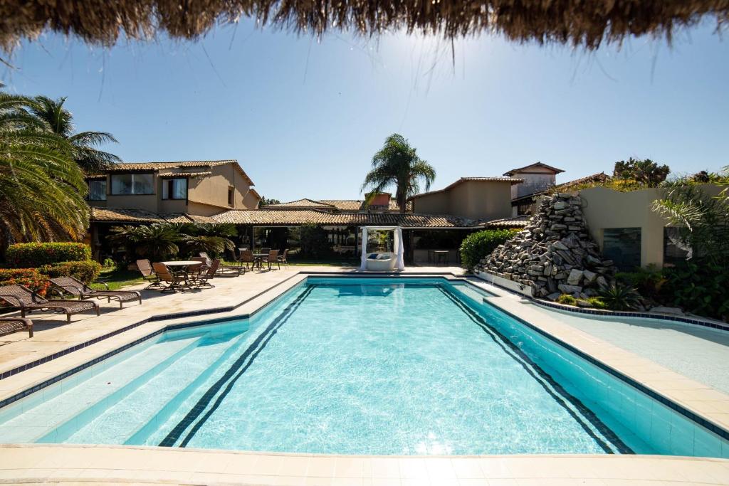 a swimming pool in front of a house at Pousada Casa do Catavento in Búzios