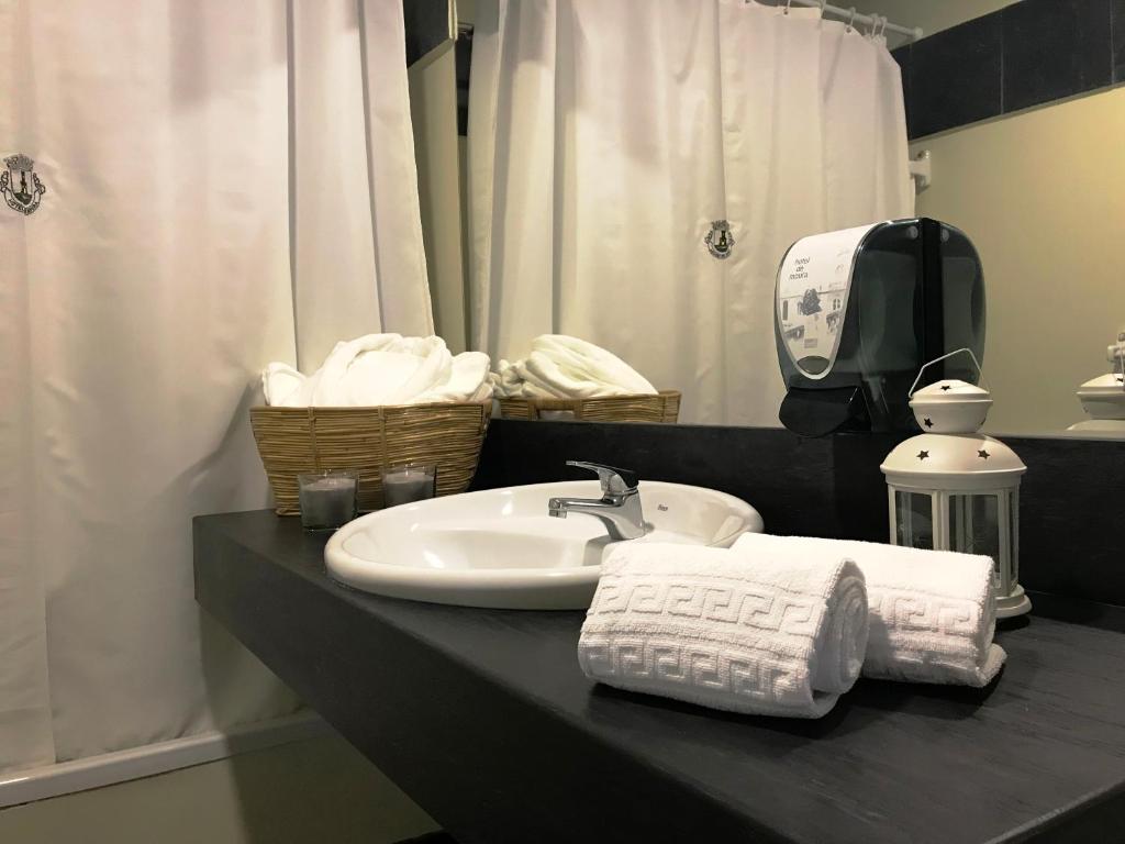 a bathroom with a sink and towels on a counter at Hotel de Moura in Moura