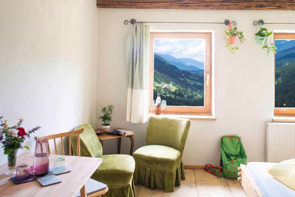 a living room with a table and chairs and a window at Hepi Lodge in Liesing