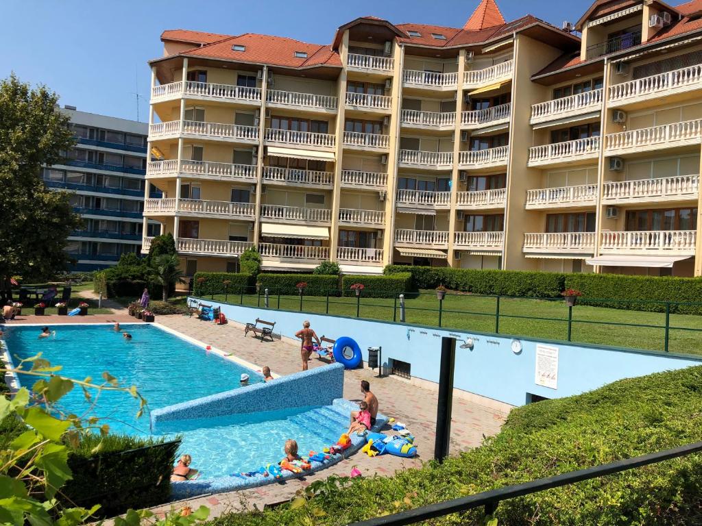 un hotel con piscina frente a un edificio en Fured Apartments, en Balatonfüred