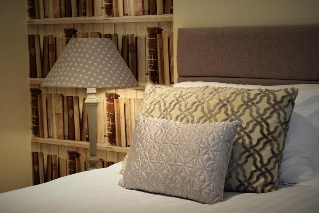 a bed with a pillow and a lamp next to a book shelf at Meridian Way - 3 Bed Apartment - Sleeps 7 in Bristol