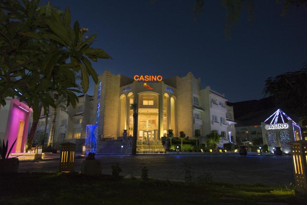 Taba Sands Hotel & Casino - Adult Only في طابا: مبنى عليه علامة سيرك في الليل