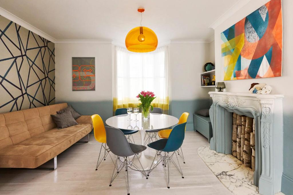a living room with a table and chairs and a couch at Stylish Seaside Maisonette - 200m to Beach in Brighton & Hove