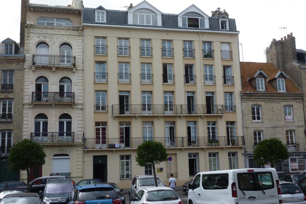 duży budynek z samochodami zaparkowanymi przed nim w obiekcie Les Galets w mieście Dieppe