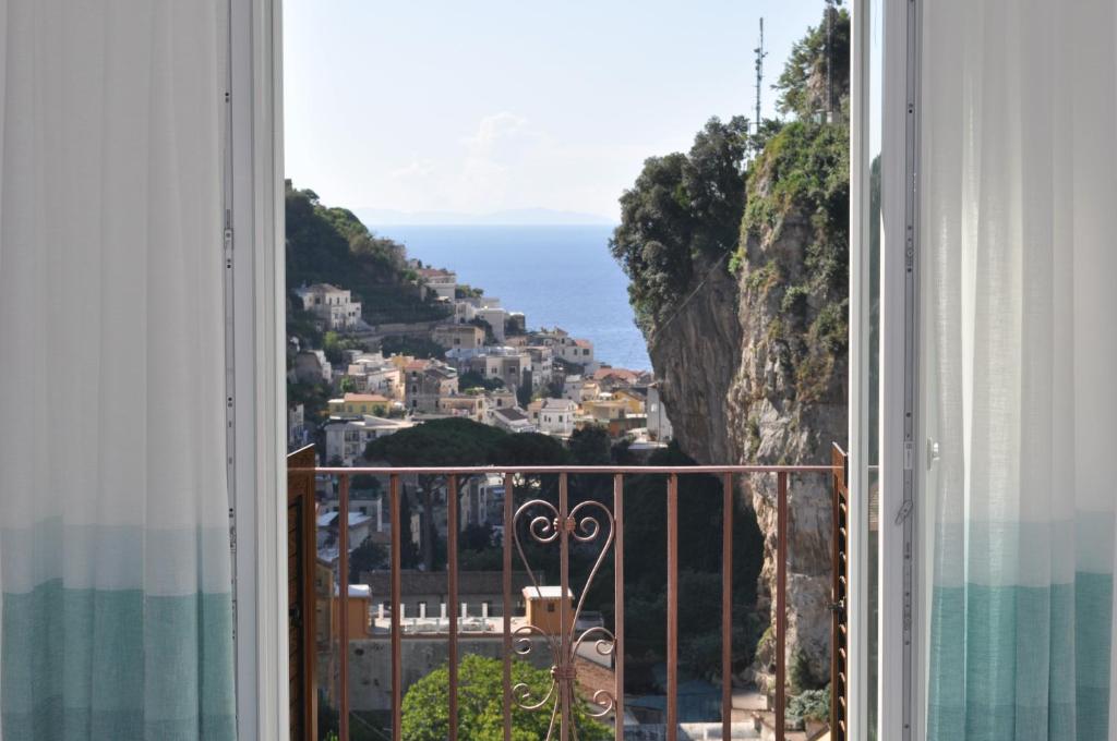 een open raam met uitzicht op de oceaan bij Via Paradiso in Amalfi