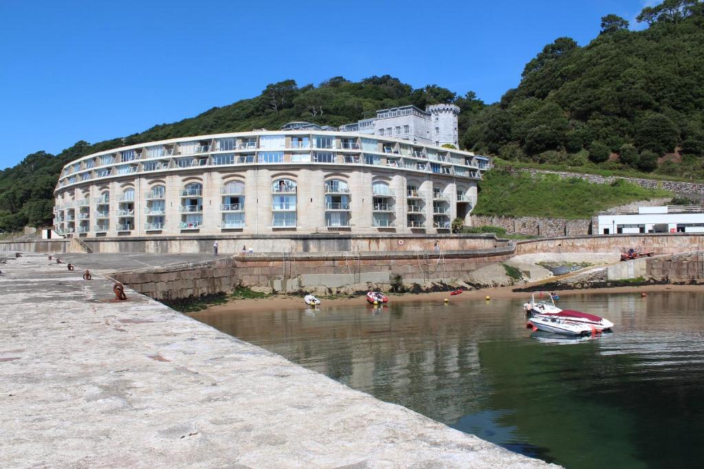 a building on the river with a boat in the water at Ocean View in Cawsand