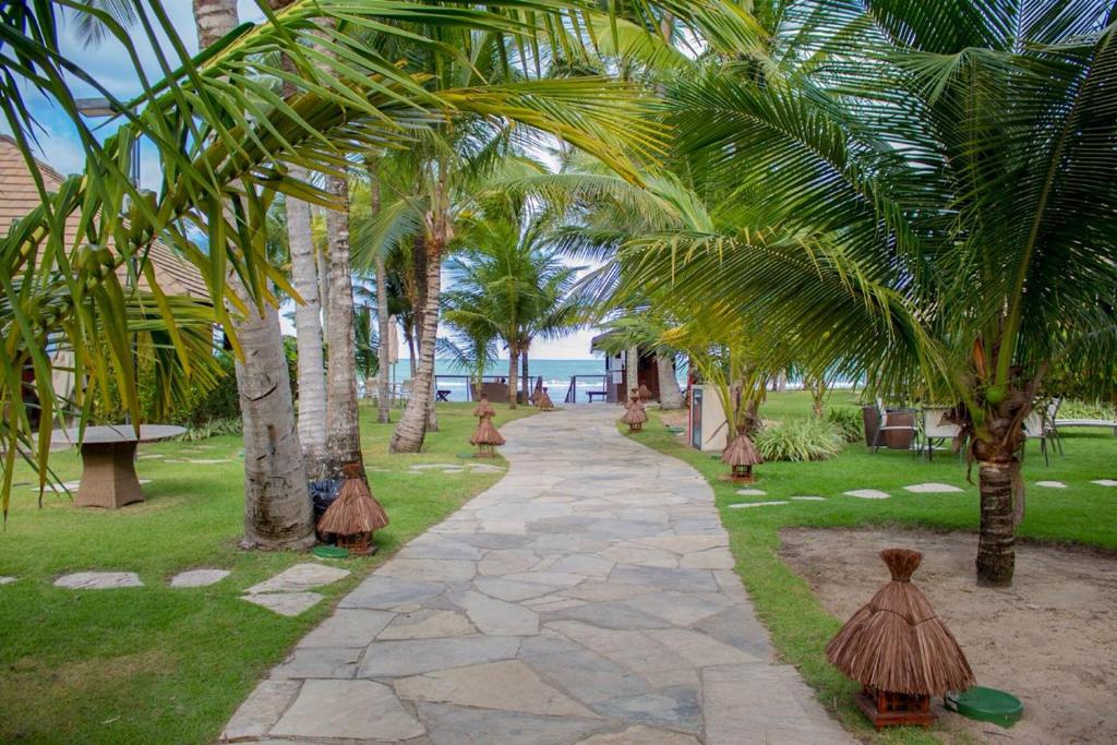 une passerelle traversant un complexe avec des palmiers dans l'établissement Nannai Residence, à Porto de Galinhas