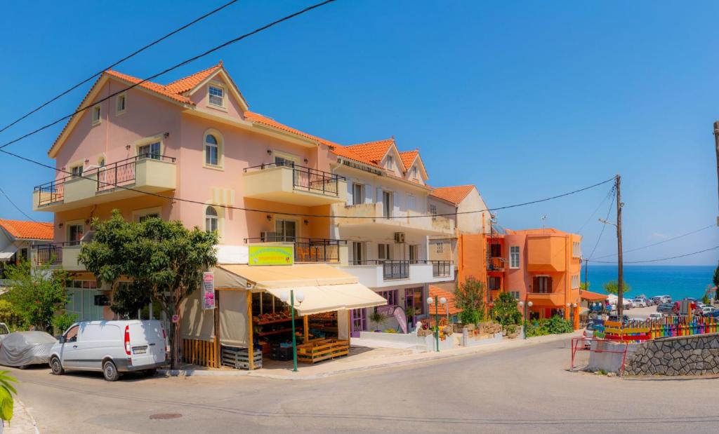 un edificio al lado de una calle junto al océano en Valsamis Villa Apartments, en Póros