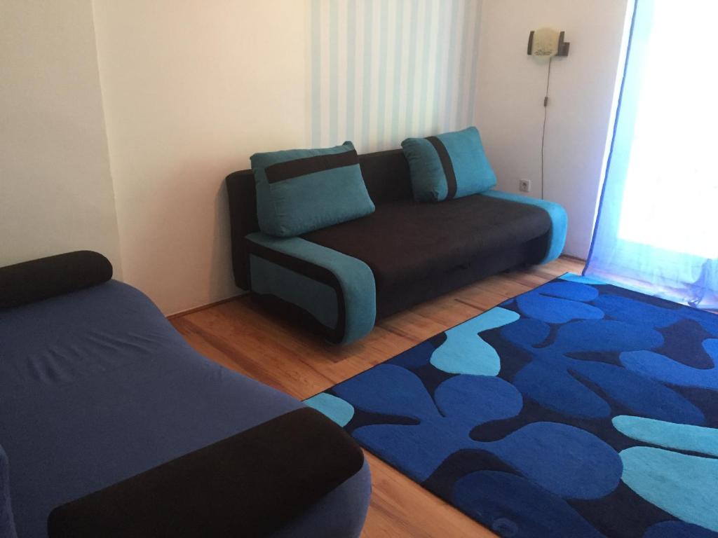 - un salon avec un canapé et un tapis dans l'établissement Lellei vízparti apartman homokos strandnál, à Balatonlelle