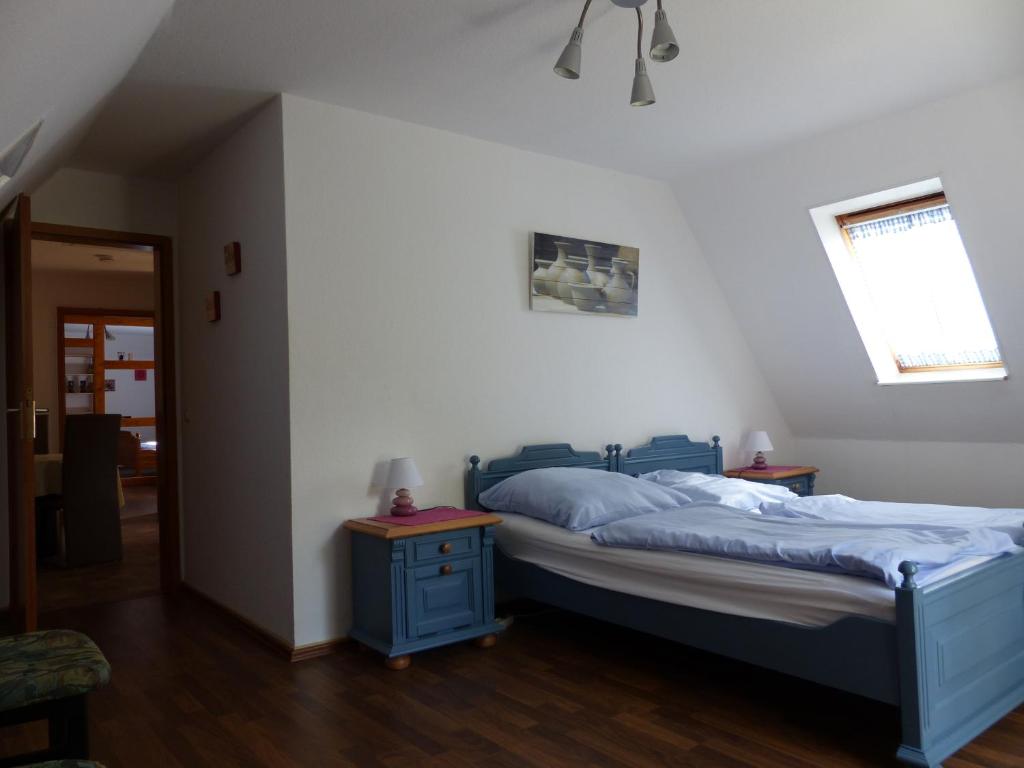 リューネブルクにあるFerienwohnung Liebesgrundのベッドルーム1室(青いベッド1台、テーブル2台付)