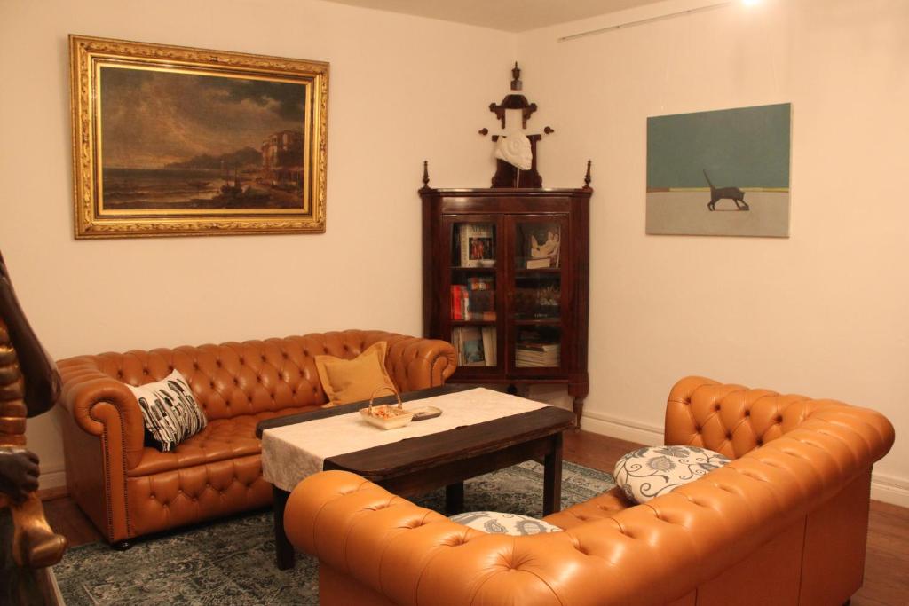 ein Wohnzimmer mit 2 Ledersofas und einem Tisch in der Unterkunft Ferienhaus am Kunstspeicher in Lübz