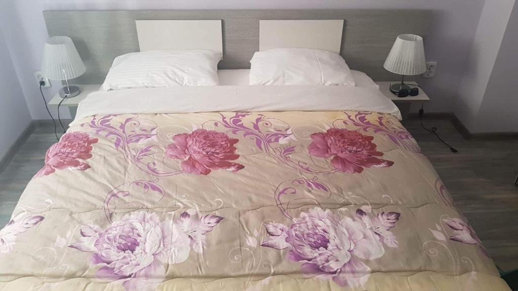 a bed with a blanket with flowers on it at Saraya in Varna City
