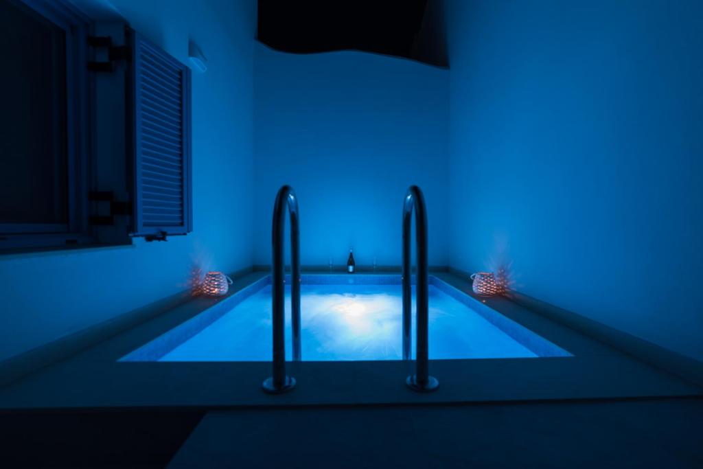 una piscina con luci blu in una stanza di Gina's Cozy House a Kamilari