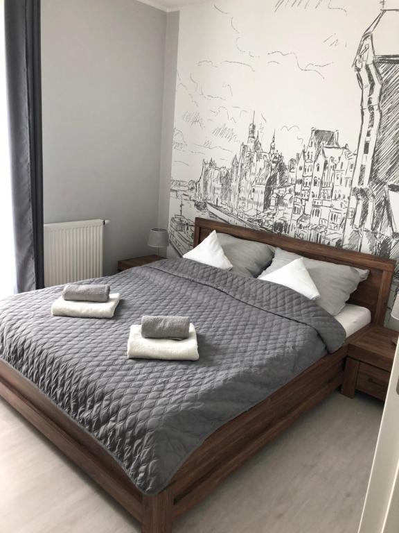 una camera da letto con un letto e due asciugamani di Mieszkanie w Riverside w centrum Starego Miasta a Danzica