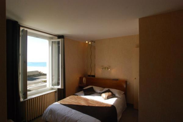 - une chambre avec un lit et une fenêtre dans l'établissement Alpha Ocean, à Saint-Malo