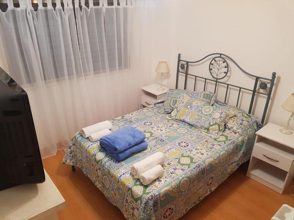 1 dormitorio con 1 cama con sábanas y almohadas azules en Suipacha Obelisco Departamento Familiar en Buenos Aires