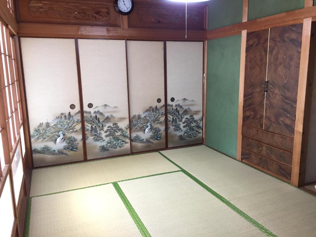 a corner of a room with paintings on the wall at Ibusiki Chinese Minshuku in Ibusuki