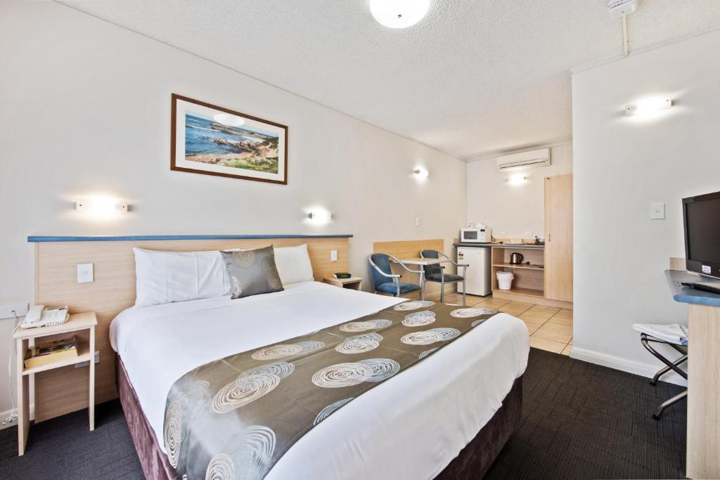 een hotelkamer met een groot bed en een televisie bij Welcome Inn 277 in Adelaide