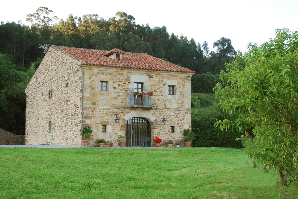 un antiguo edificio de piedra con una puerta en un campo en Posada Camino del Norte en Güemes