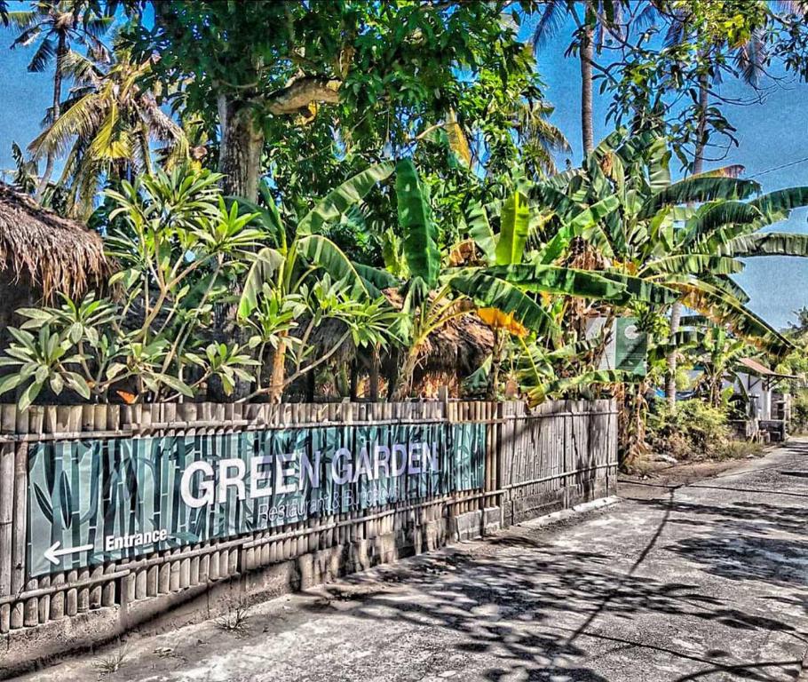 una cerca con un letrero de jardín verde. en Green Garden Lembongan Yoga Spa and Holistic Healing Center, en Nusa Lembongan
