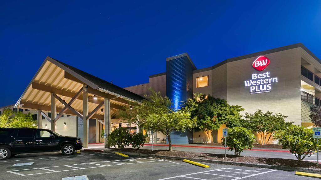 een best western plus gebouw met een auto geparkeerd op een parkeerplaats bij Best Western Plus Silverdale Beach Hotel in Silverdale
