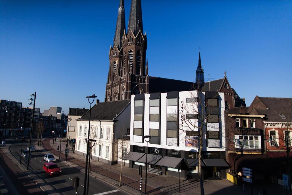 a large church with a tall steeple in a city at City Hotel Tilburg in Tilburg