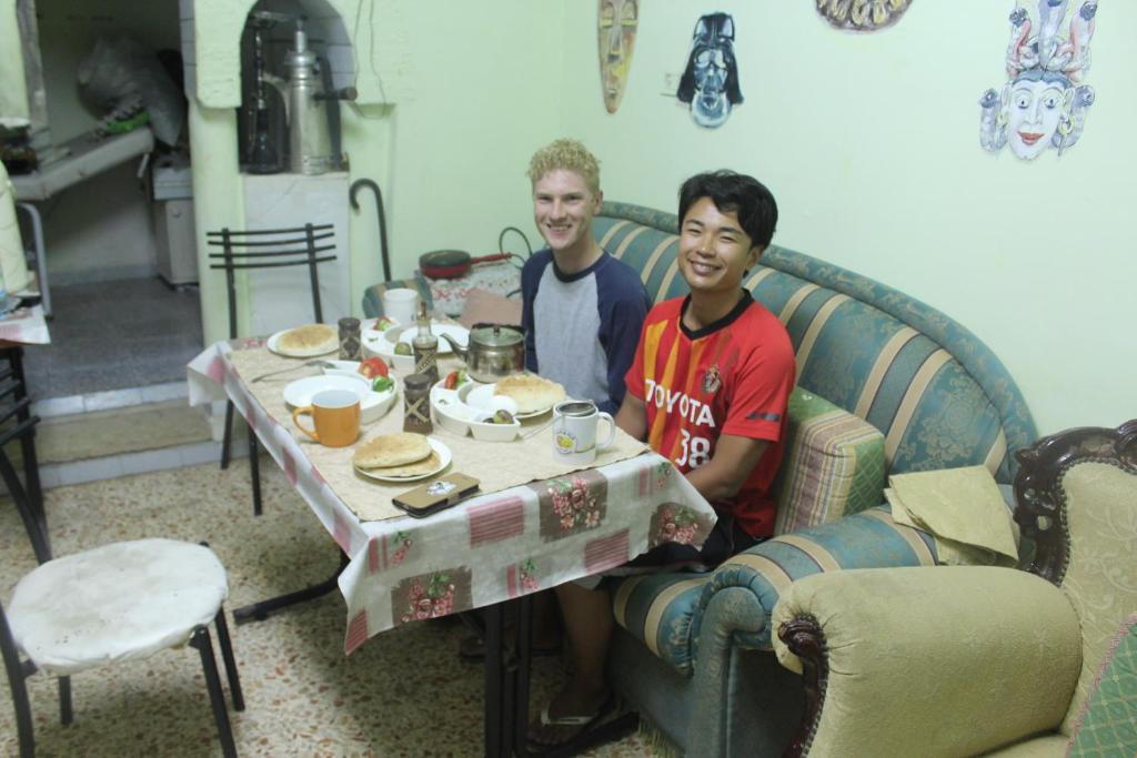 Due uomini seduti a un tavolo in un soggiorno di Bunksurfing Hostel a Bethlehem