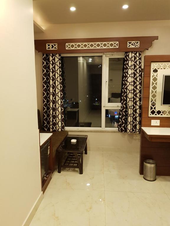 a living room with a table and a window at Hotel Banaras Haveli in Varanasi