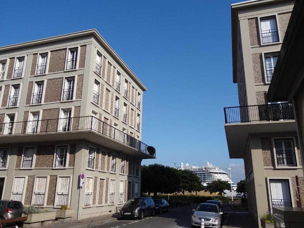 an apartment building with cars parked in front of it at Le Perret in Le Havre