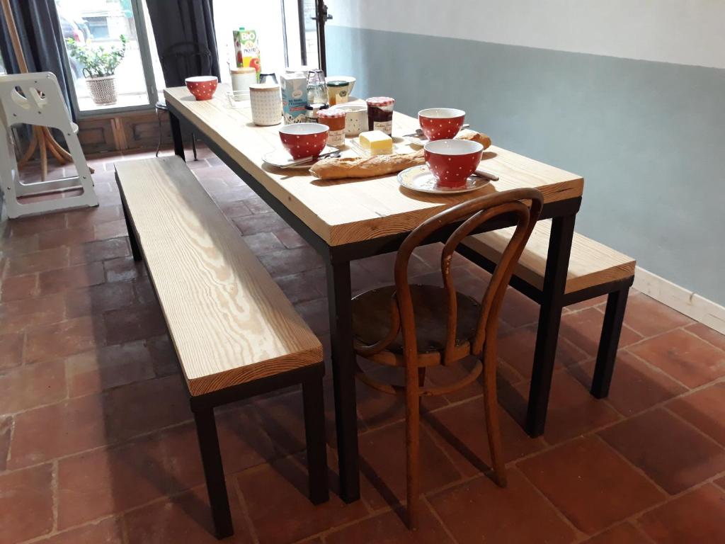 a wooden table with two benches and a table and chairs at File dans ta chambre ! in Le Monastier sur Gazeille