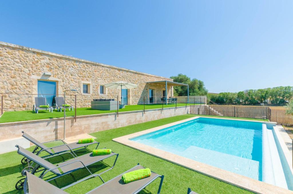 a villa with a swimming pool and patio furniture at Es Gassons in Maria de la Salut