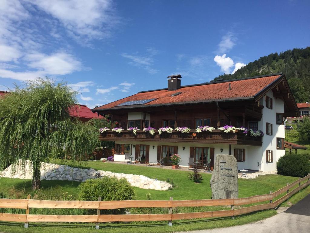 a house with flowers on the front of it at Haus Am Wiesbach in Reit im Winkl