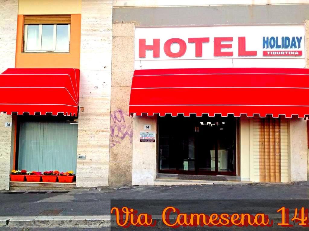 ローマにあるTiburtina Hotel Holidayの建物側の赤い日よけのホテル
